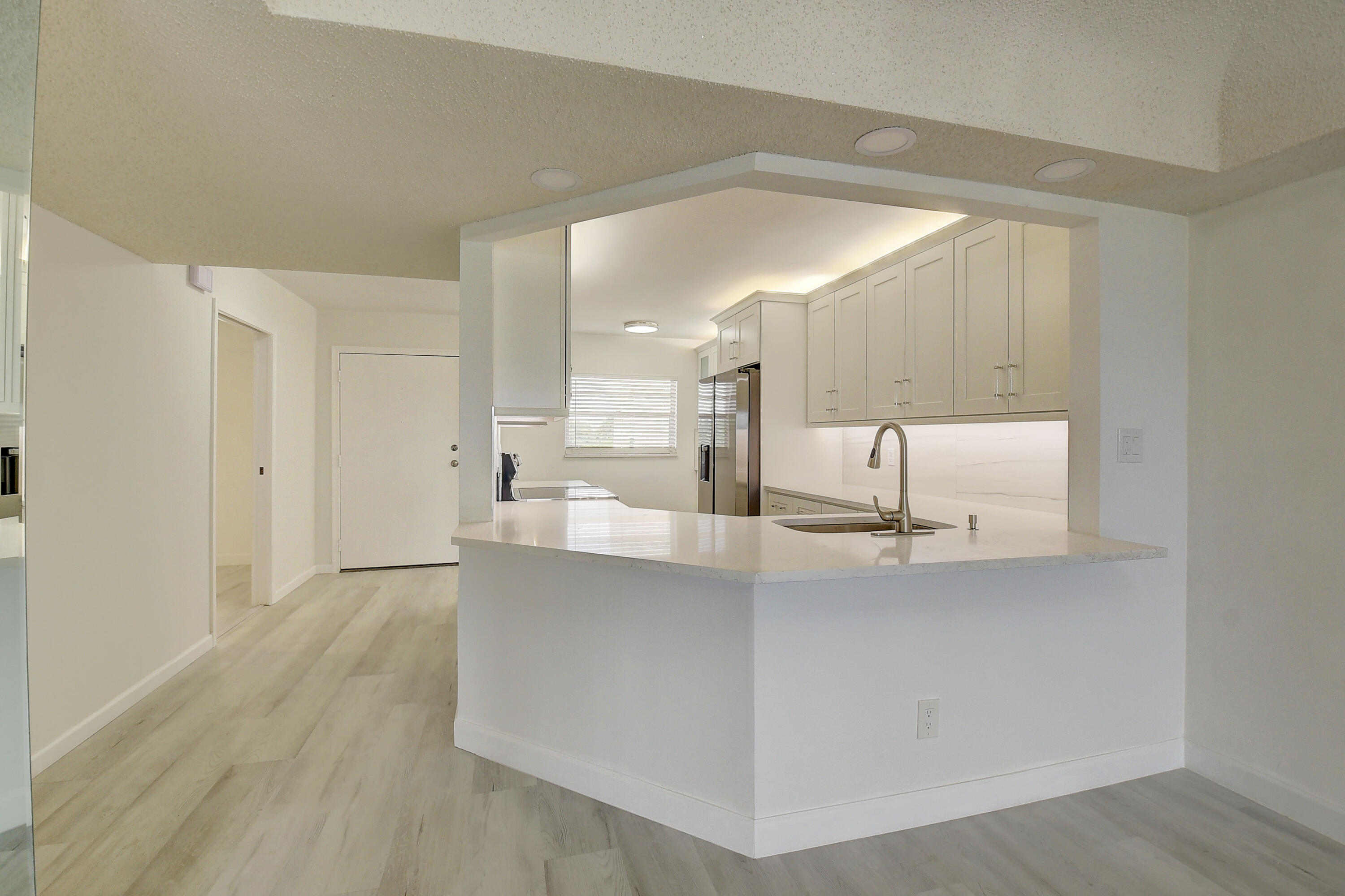 23305 Barwood Lane North, Unit 406 Boca Raton, FL 33428 - Photo 9 of 41 a view of kitchen with center island wooden floor and living room
