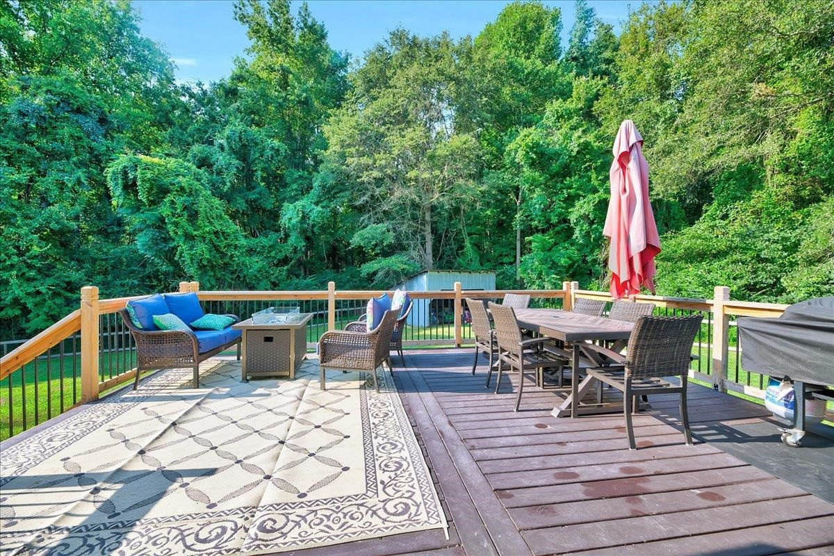 2222 Zacks Mill Road Angier, NC 27501 - Photo 12 of 48 a view of a patio with a dining table and chairs with wooden floor and fence