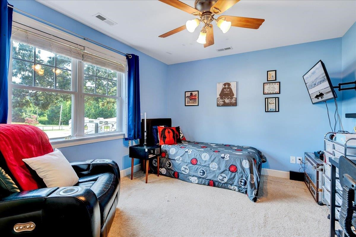 2222 Zacks Mill Road Angier, NC 27501 - Photo 42 of 48 a bedroom with a bed and a chandelier
