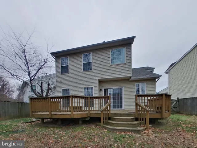 a view of a house with a yard and wooden deck