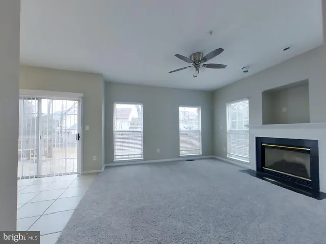 a view of an empty room with a fireplace and a window