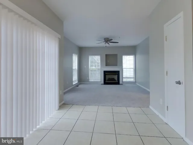 a view of an empty room with a fireplace and a window