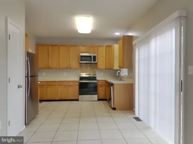 a kitchen with a refrigerator sink and cabinets