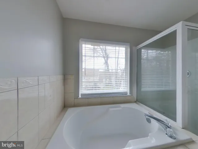 a white bath tub sitting in a bathroom next to a window