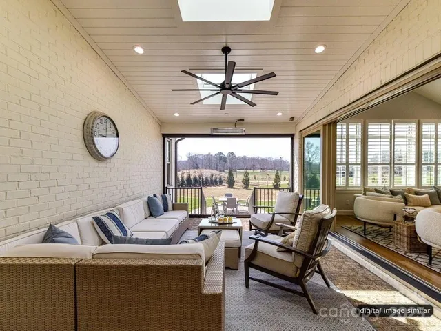 a living room with furniture a clock and a large window