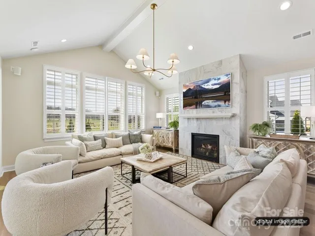 a living room with furniture fireplace and large windows