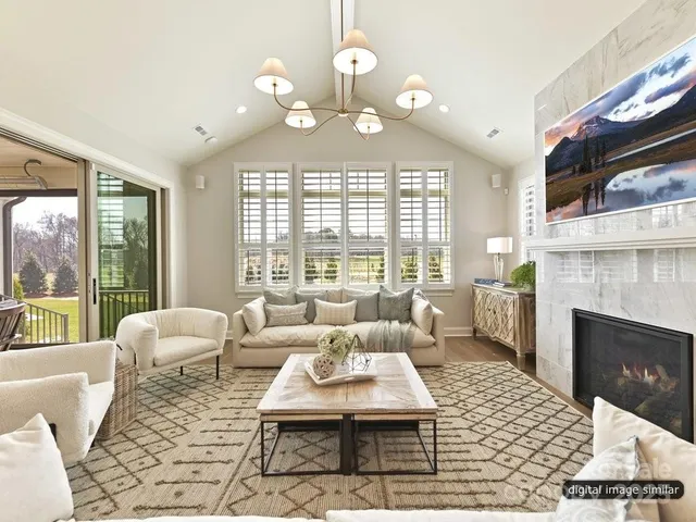 a living room with furniture chandelier and a fireplace