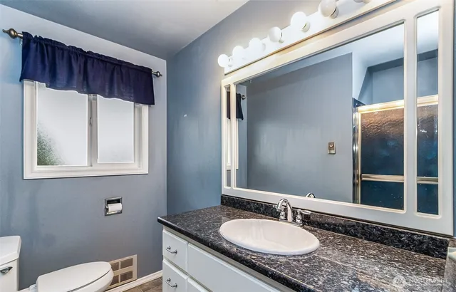 a bathroom with a granite countertop sink and a mirror