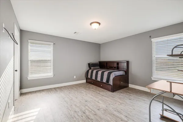 a bedroom with a bed and wooden floor