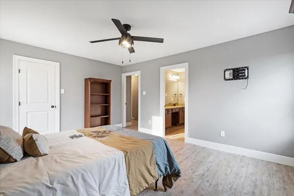 a bedroom with a large bed and a chandelier
