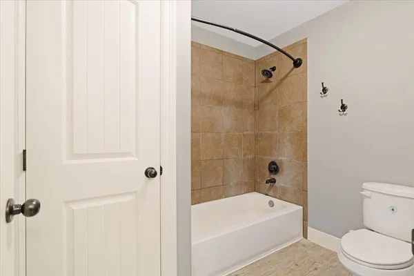 a bathroom with a white bath tub a toilet and a shower