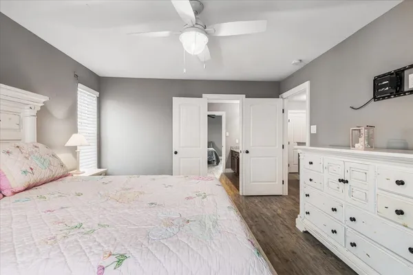 a bedroom with a bed a chandelier and a dresser