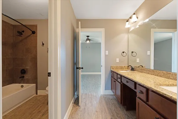 a spacious bathroom with a granite countertop sink mirror and a bath tub