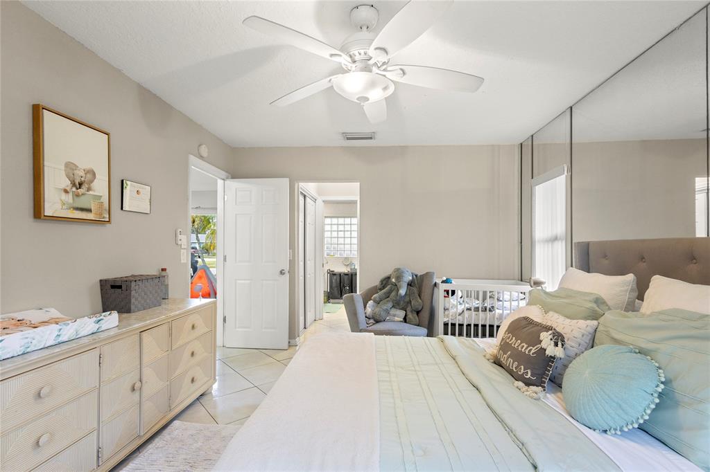 10344 Dorchester Drive Boca Raton, FL 33428 - Photo 11 of 30 a bedroom with a bed and a chandelier