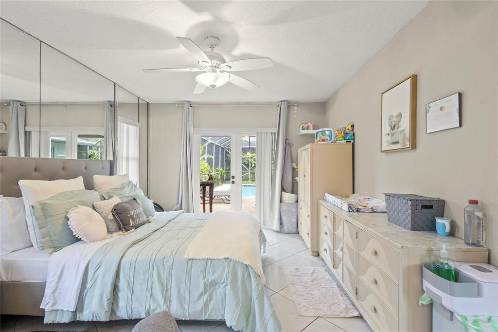 10344 Dorchester Drive Boca Raton, FL 33428 - Photo 12 of 30 a bedroom with a bed and a chandelier