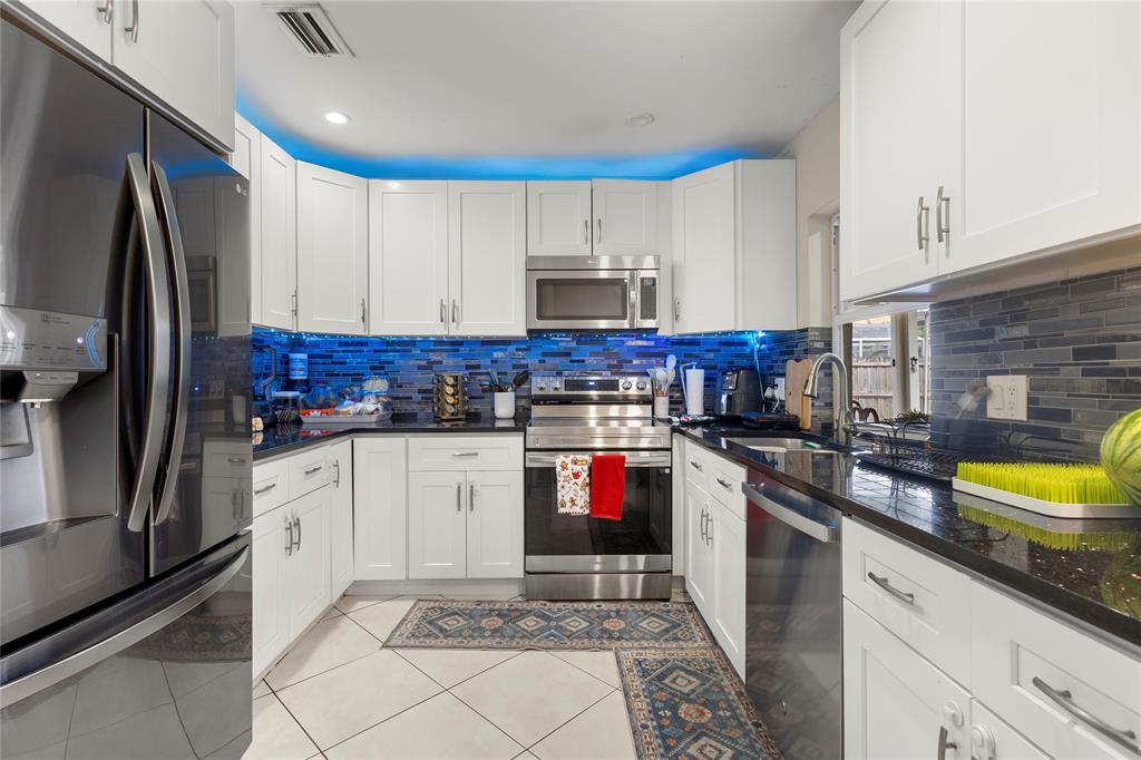 10344 Dorchester Drive Boca Raton, FL 33428 - Photo 7 of 30 a kitchen with stainless steel appliances granite countertop a stove a sink and a refrigerator