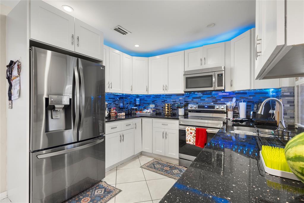 10344 Dorchester Drive Boca Raton, FL 33428 - Photo 8 of 30 a kitchen with stainless steel appliances granite countertop a refrigerator sink and stove