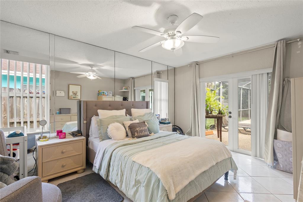 10344 Dorchester Drive Boca Raton, FL 33428 - Photo 10 of 30 a bedroom with a bed and a chandelier