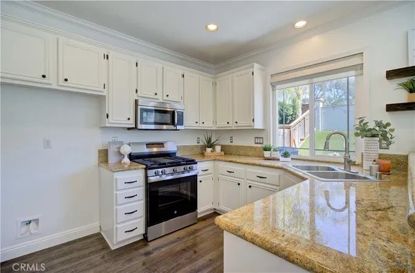 a kitchen with granite countertop a stove and a sink