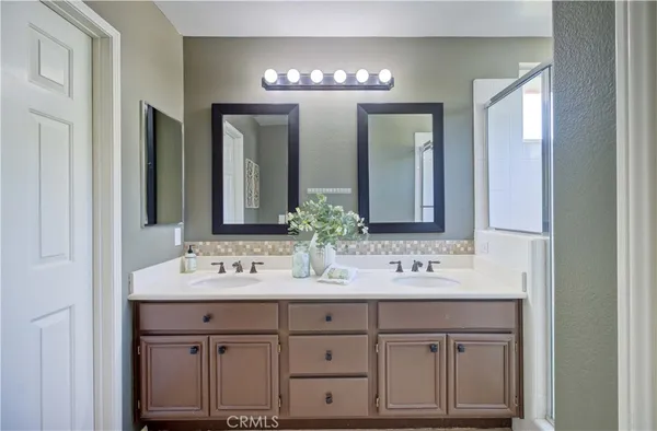 a bathroom with double sink and a mirror