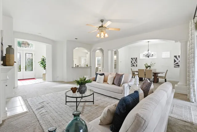 a living room with furniture a chandelier and a window