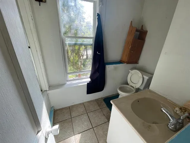 a bathroom with a toilet mirror and sink