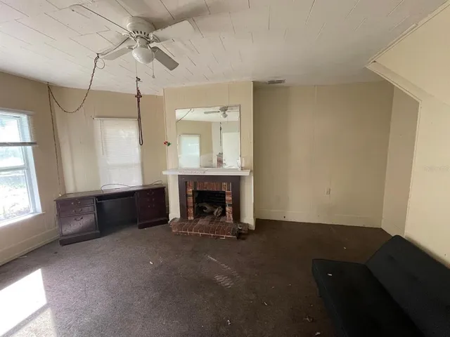 a view of an empty room with a fireplace and a window