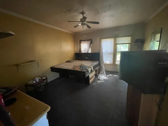 a spacious bedroom with a bed and a chandelier