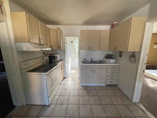 a kitchen with a stove sink and cabinets