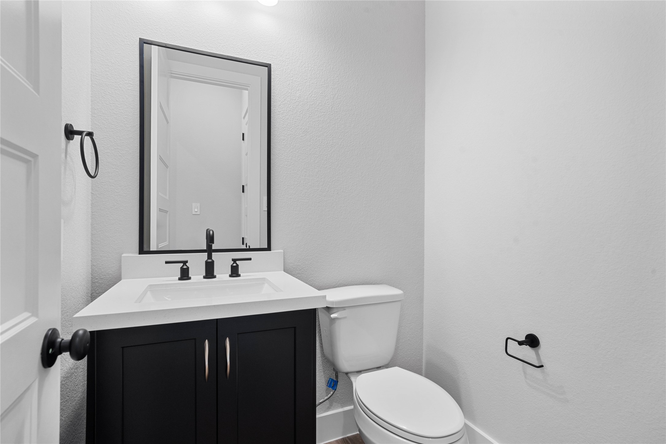 2114 Rowl Street Montgomery, TX 77316 - Photo 17 of 50 This chic modern powder room is perfect for guests! It features a vanity, quartz counter, matte black hardware, matching framed mirror, and designer towel and tissue holders.