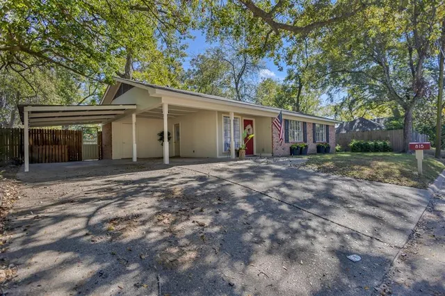 front view of a house with a yard and potted plants