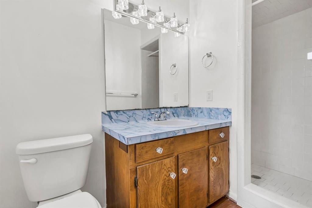 815 North Bledsoe Street Gilmer, TX 75644 - Photo 22 of 26 a bathroom with a granite countertop sink toilet and shower