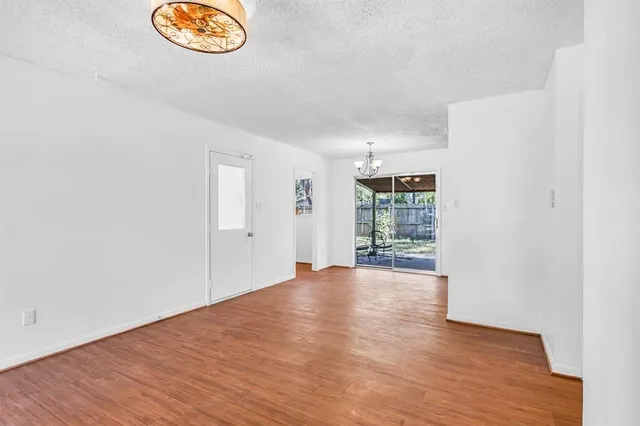 an empty room with wooden floor and window