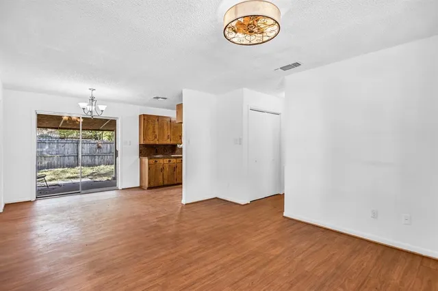 an empty room with wooden floor and a window