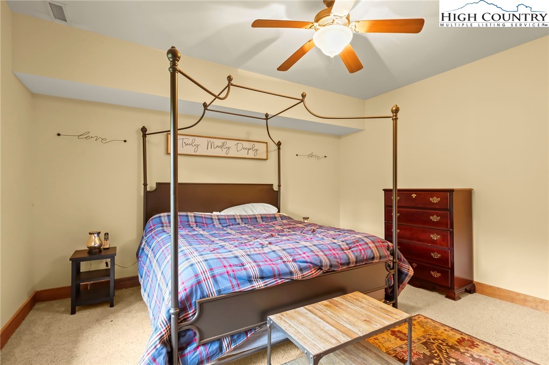 138 South Camp Road, Unit 103 Boone, NC 28607 - Photo 39 of 50 a bedroom with a bed a dresser and a chandelier