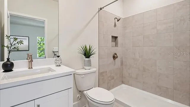 a bathroom with a sink mirror vanity and toilet