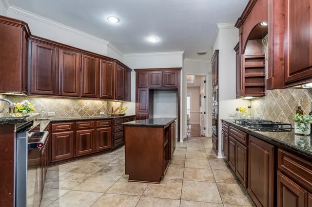 a kitchen with stainless steel appliances granite countertop wooden cabinets a stove top oven a sink and dishwasher