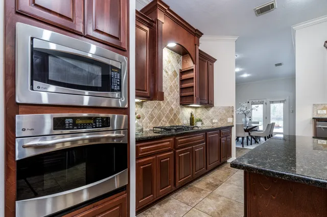 a kitchen with stainless steel appliances kitchen island granite countertop a stove microwave and sink