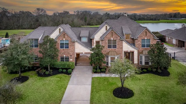 a aerial view of a house next to a yard with plants and large trees