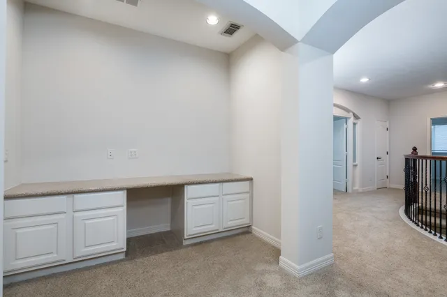 an empty room with a cabinet and mirrors