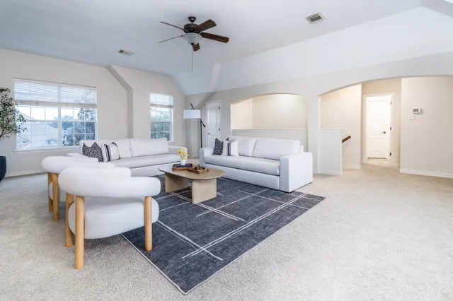 a living room with furniture a rug and a chandelier