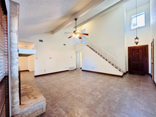 a view of an empty room with a fireplace and a window