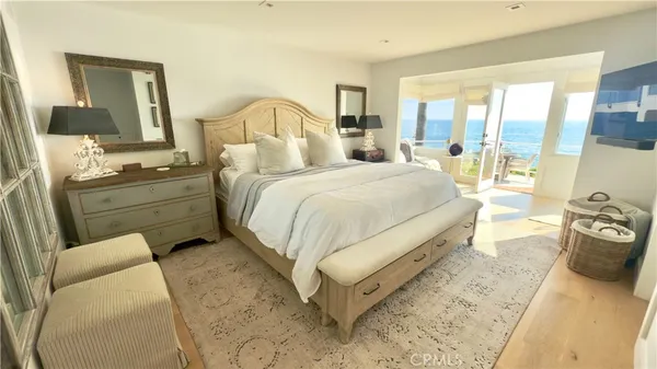 a spacious bedroom with a bed and wooden floor