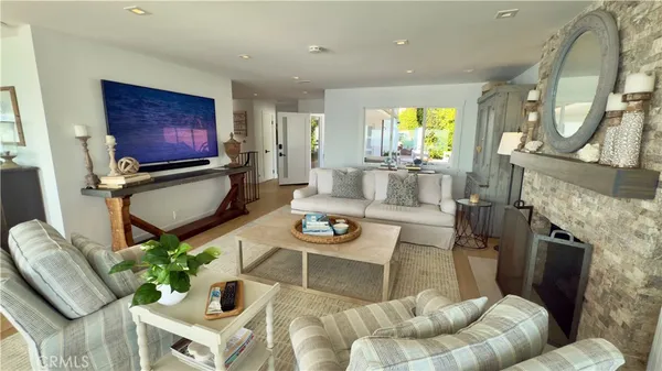 a living room with furniture a fireplace and a floor to ceiling window