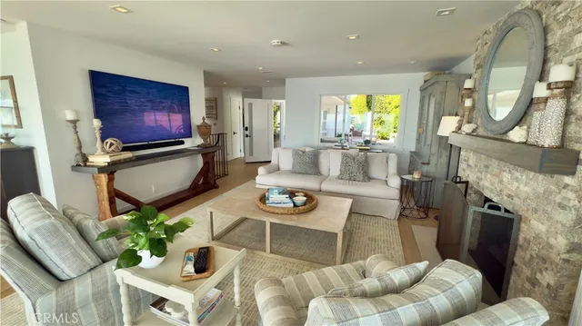 a living room with furniture a fireplace and a floor to ceiling window