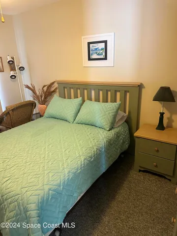 a bed sitting in a bedroom next to a window with a dresser