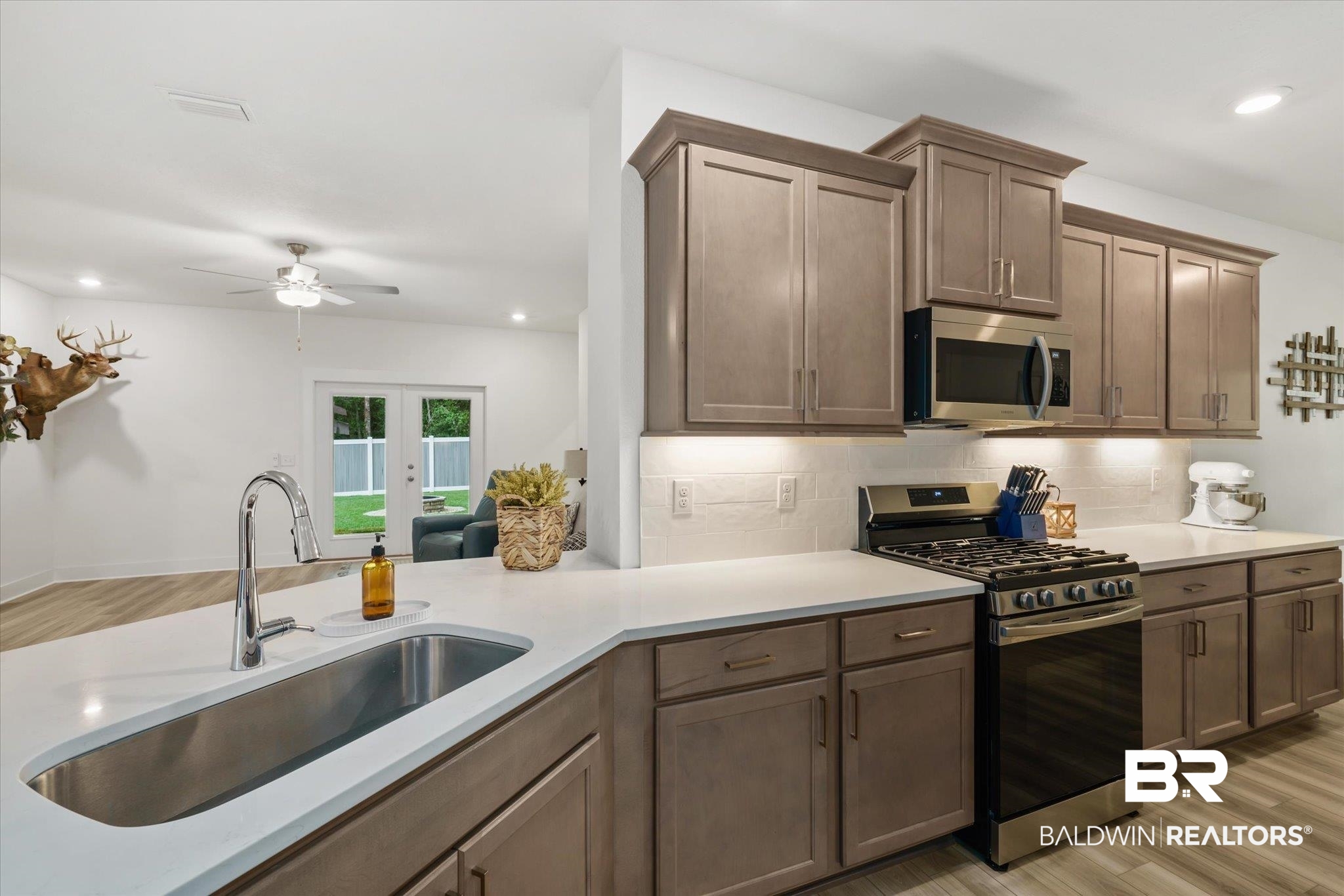 263 Bronze Street Fairhope, AL 36532 - Photo 8 of 47 Kitchen with appliances with stainless steel finishes, french doors, sink, ceiling fan, and light wood-type flooring