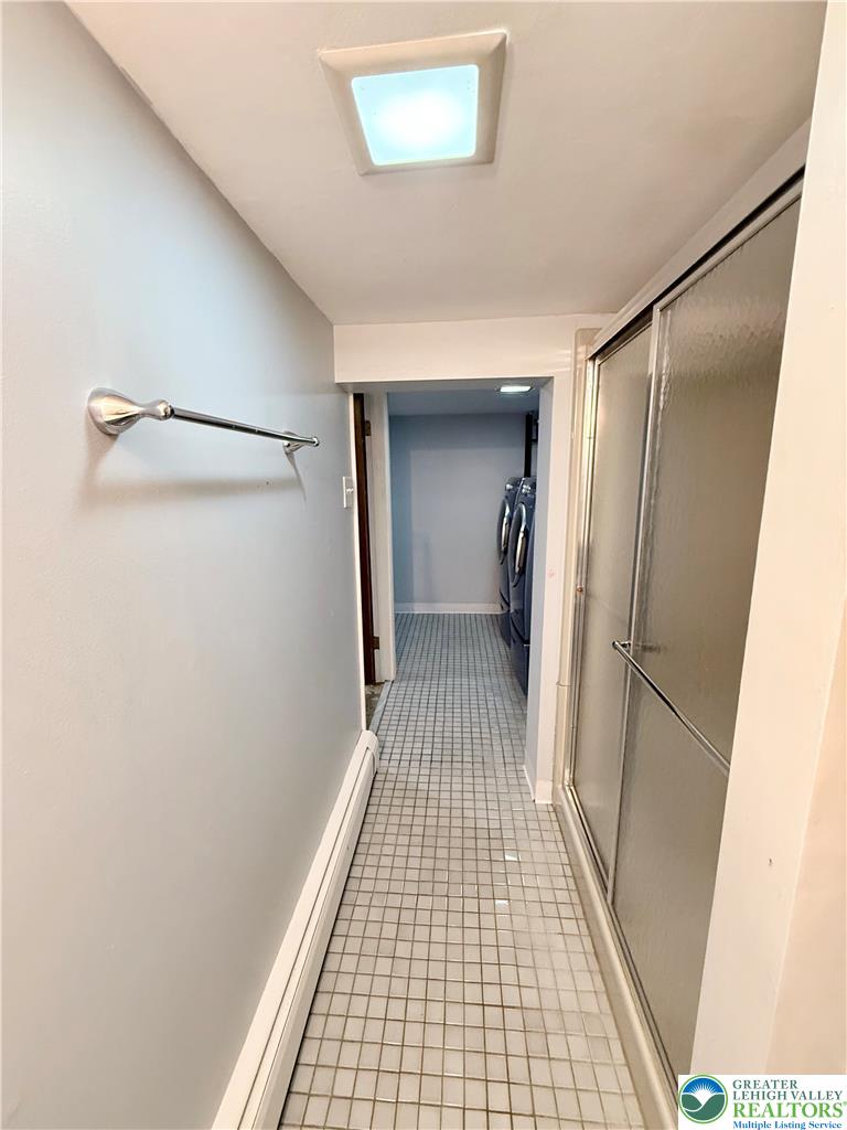 5540 Main Street Whitehall, PA 18052 - Photo 45 of 53 A well-lit interior hallway with durable tile flooring and a discreet laundry area.