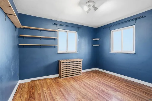 a view of a room with wooden floor and a ceiling fan