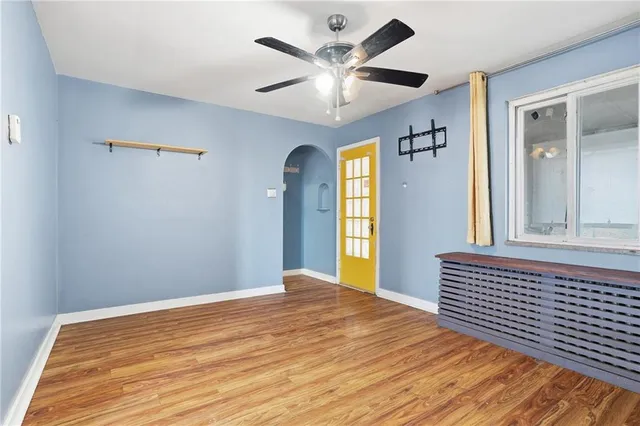 a view of a livingroom with wooden floor and a ceiling fan